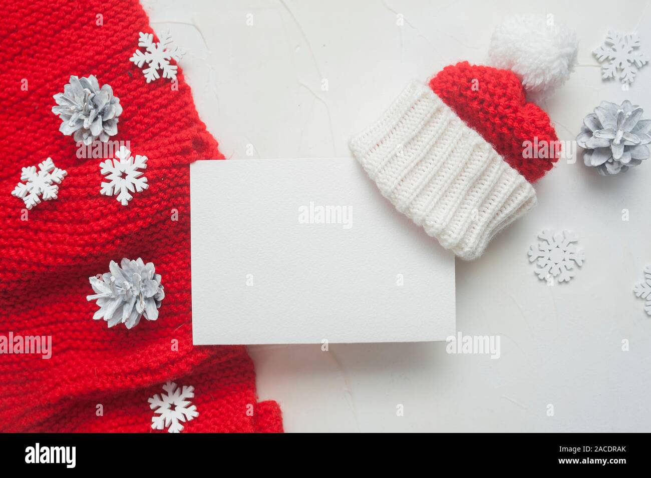 Lettre de Noël immersive au Père Noël avec écharpe en tricot rouge et chapeau sur arrière-plan avec des cônes et des flocons de neige. Place pour votre texte Banque D'Images