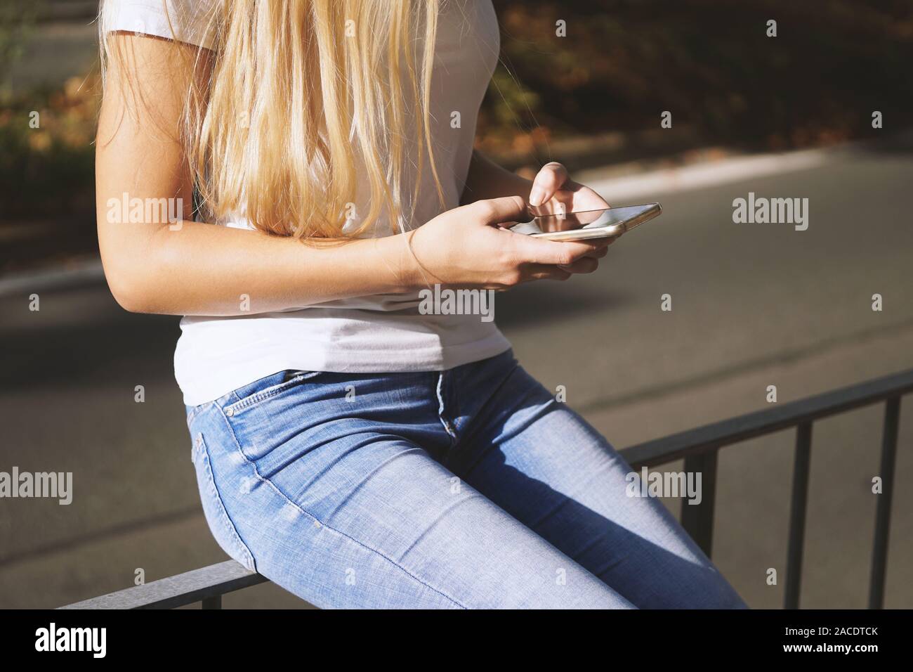 Portrait de jeune femme méconnaissable à l'aide de son téléphone intelligent ou mobile à l'extérieur on city street Banque D'Images