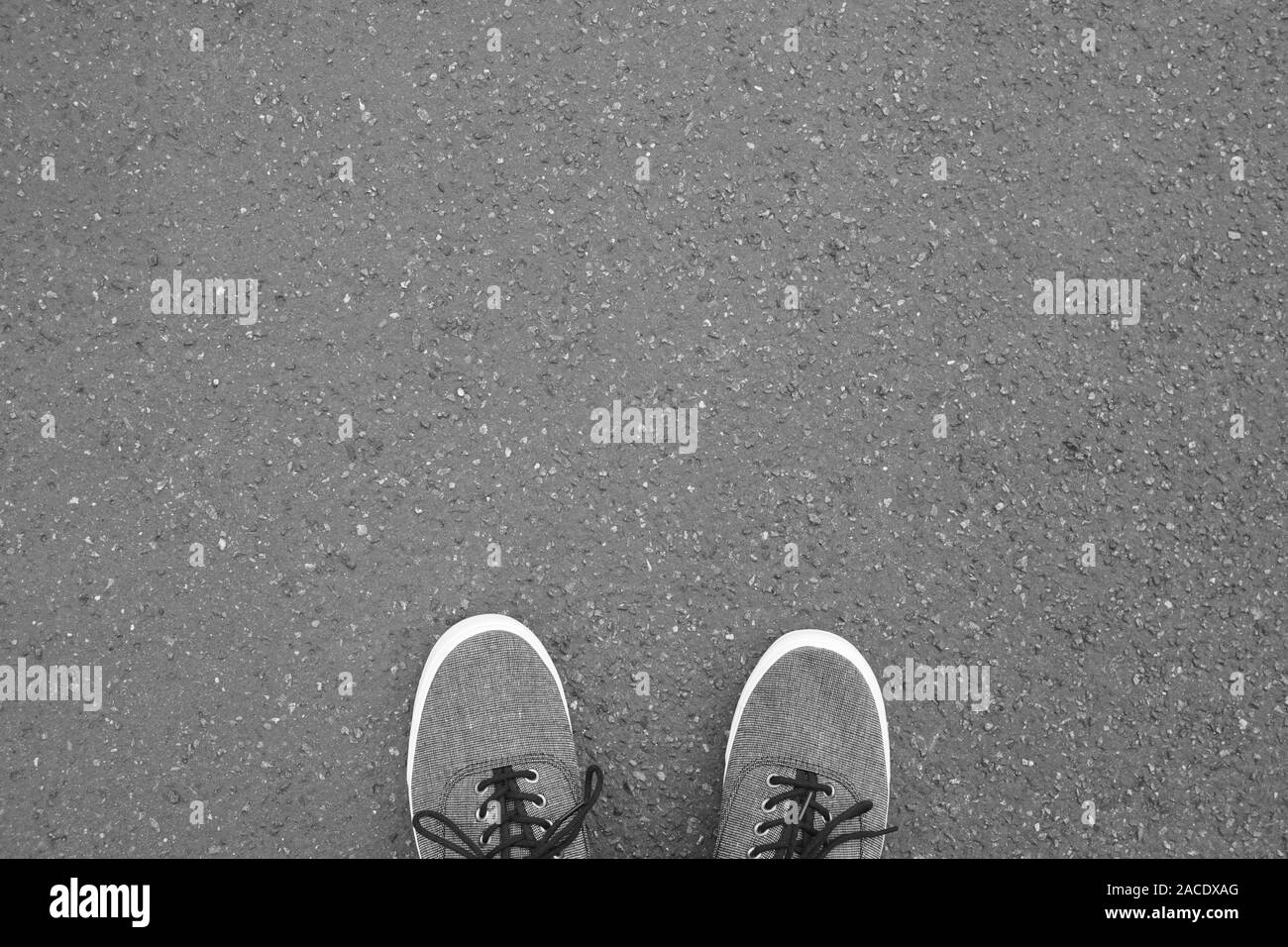 Pieds en chaussures de toile debout sur pied - rue de selfies vue personnel point de vue - Fond d'asphalte with copy space Banque D'Images