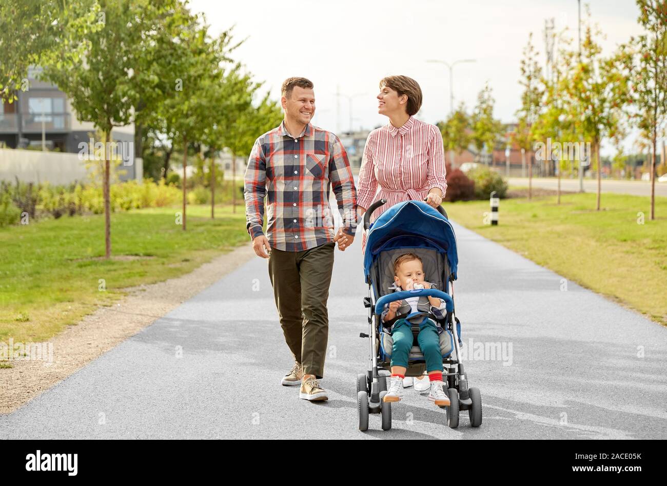Famille avec bébé et poussette marchant le long city Photo Stock - Alamy