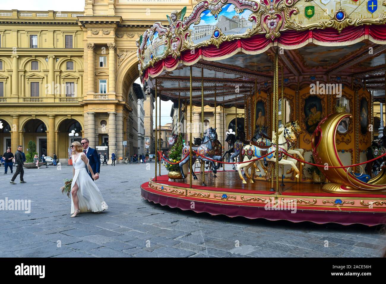 Un couple de jeunes mariés sur la place de la République dans le centre historique de Florence avec le vieux carrousel et l'Arc de Triomphe, Toscane, Italie Banque D'Images
