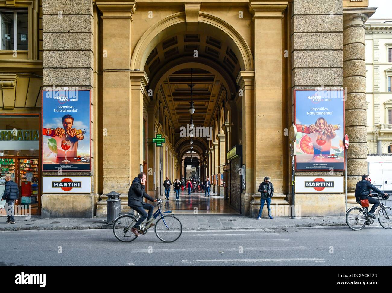 Vue de l'arcade de la place de la République dans le centre historique de Florence avec les gens sur les bicyclettes et affiches publicitaires, Toscane, Italie Banque D'Images