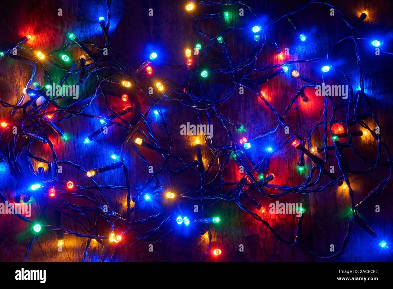 Rouge, vert, bleu et orange les lumières de Noël sur la vieille table en bois de teck Banque D'Images