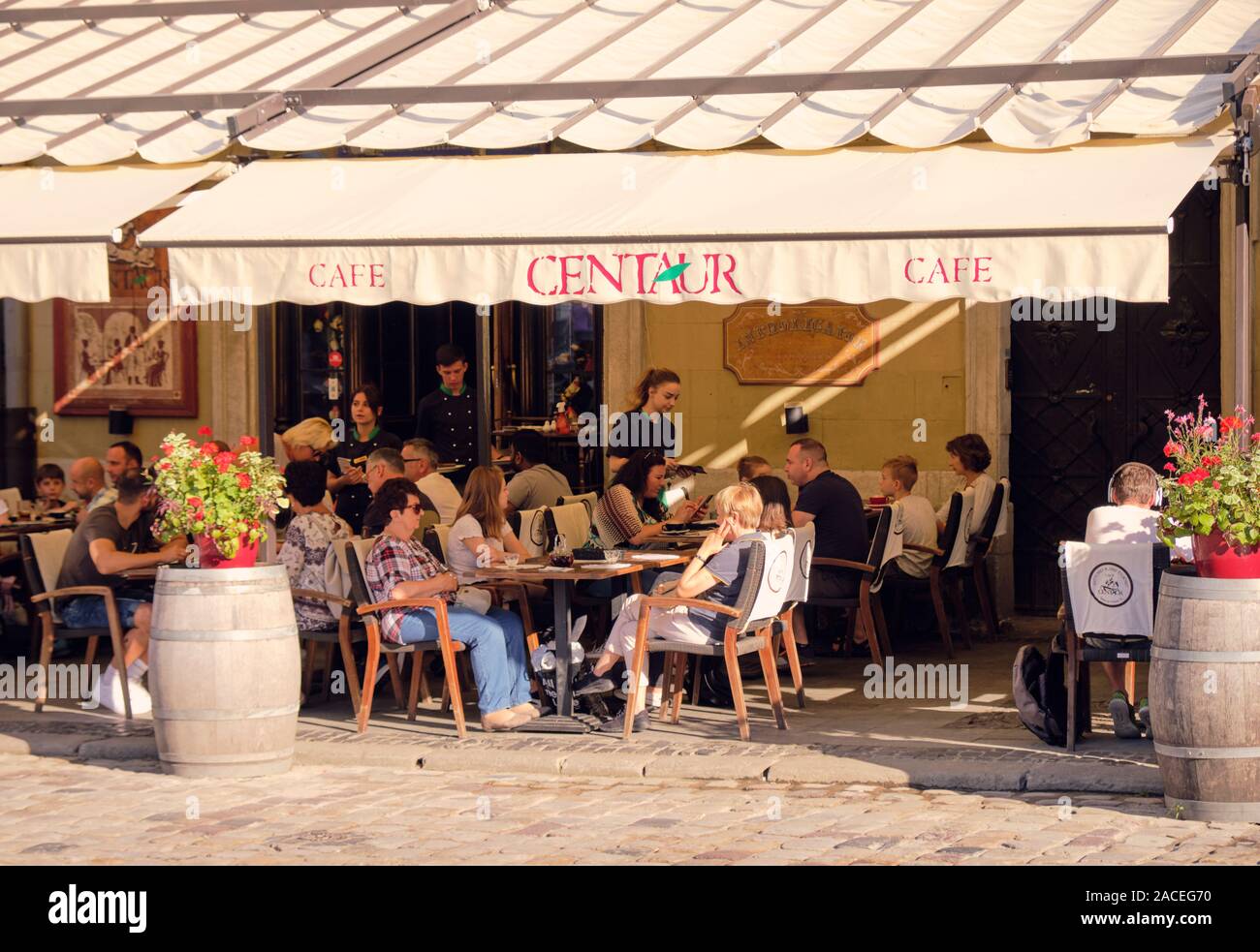 Les gens assis à un café en plein air sur un Centaure journée ensoleillée sur la place Rynok. Lviv, Ukraine Banque D'Images