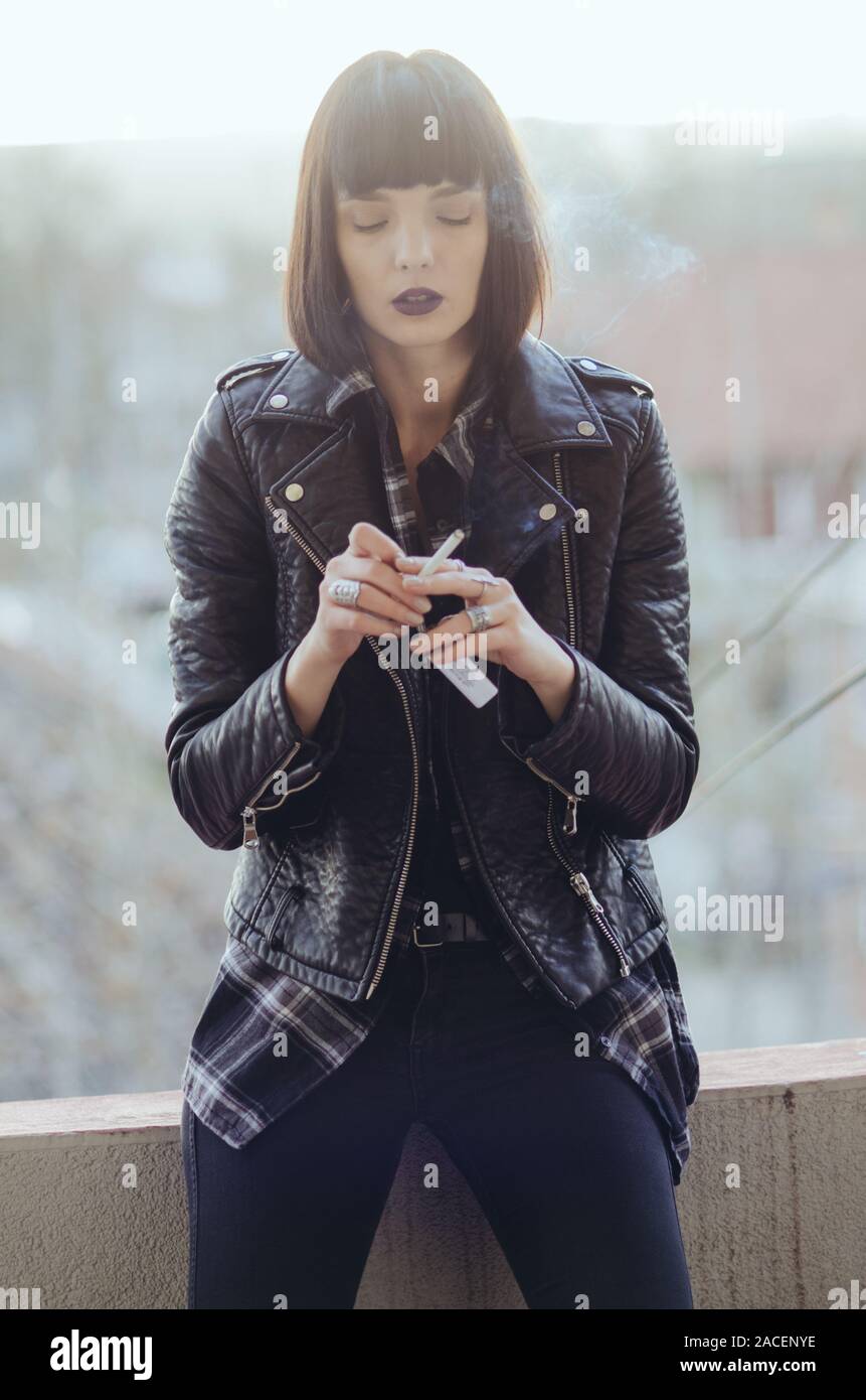 Portrait d'une jeune femme avec veste rock cigarette. Banque D'Images