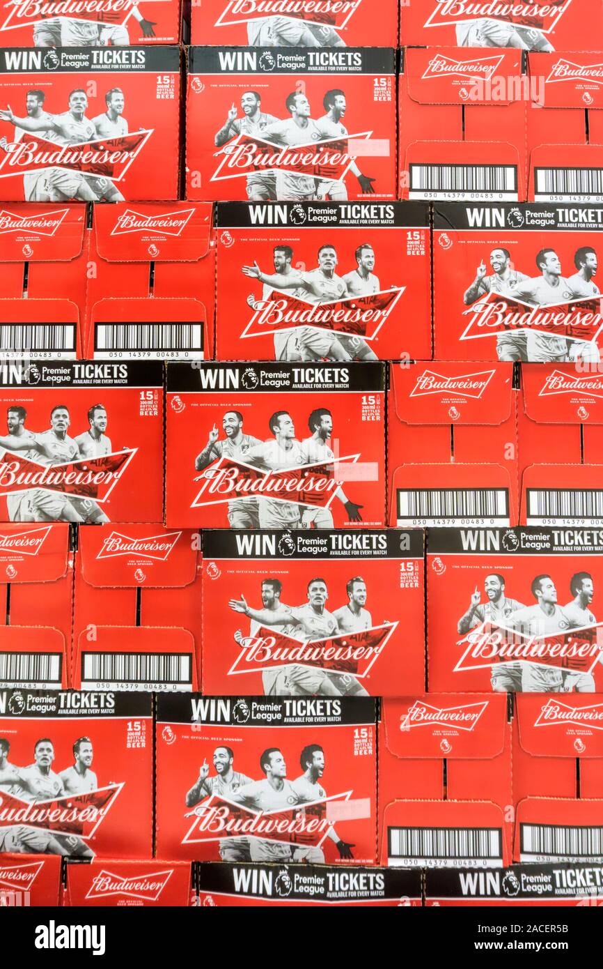 Les boîtes empilées contenant des bouteilles de bière Budweiser pour la vente dans un supermarché. Dispose d'une promotion pour gagner des billets de Premier League. Banque D'Images