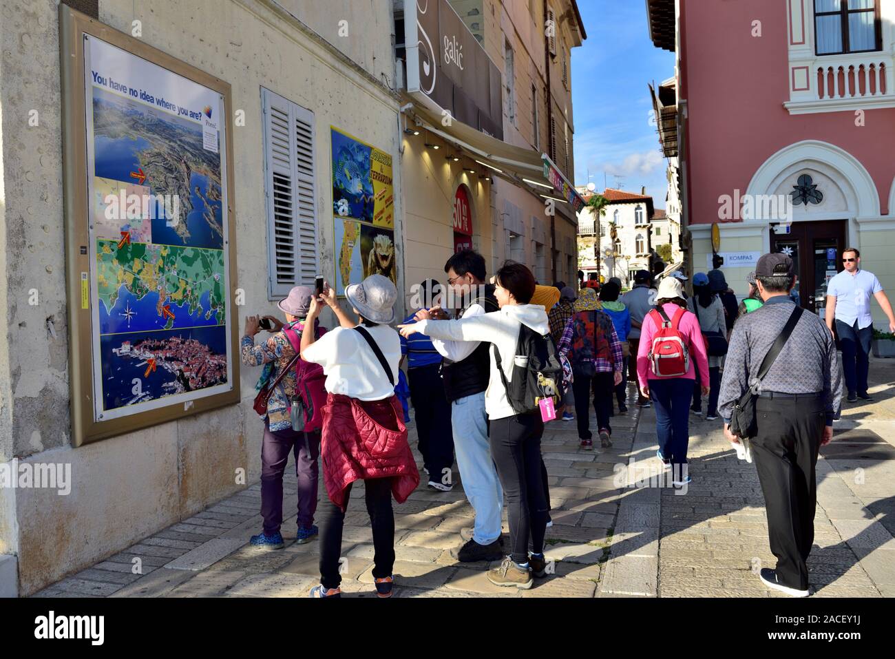 Les touristes dans la ville historique de Balkan ville de Porec, Croatie certains prenaient des photos de carte montrant l'endroit où ils sont Banque D'Images