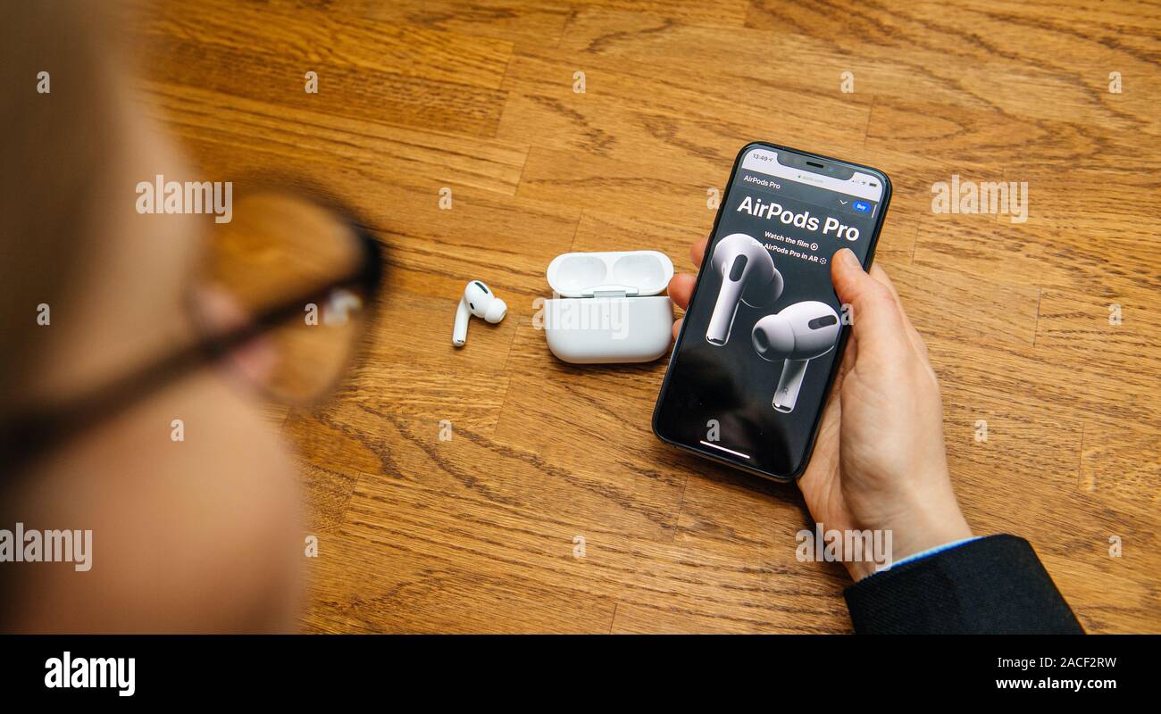 Paris, France - Oct 30, 2019 : femme mains lecture le site d'Apple sur les ordinateurs Apple AirPods Pro casque avec suppression du bruit active pour un son enveloppant Banque D'Images