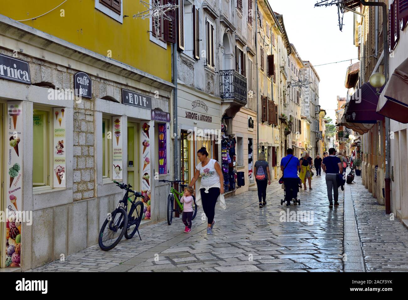 Scène de rue de pavé de marbre principalement rue piétonne commerçante (Ul. Decumanus) dans la vieille ville de Porec, Croatie Banque D'Images