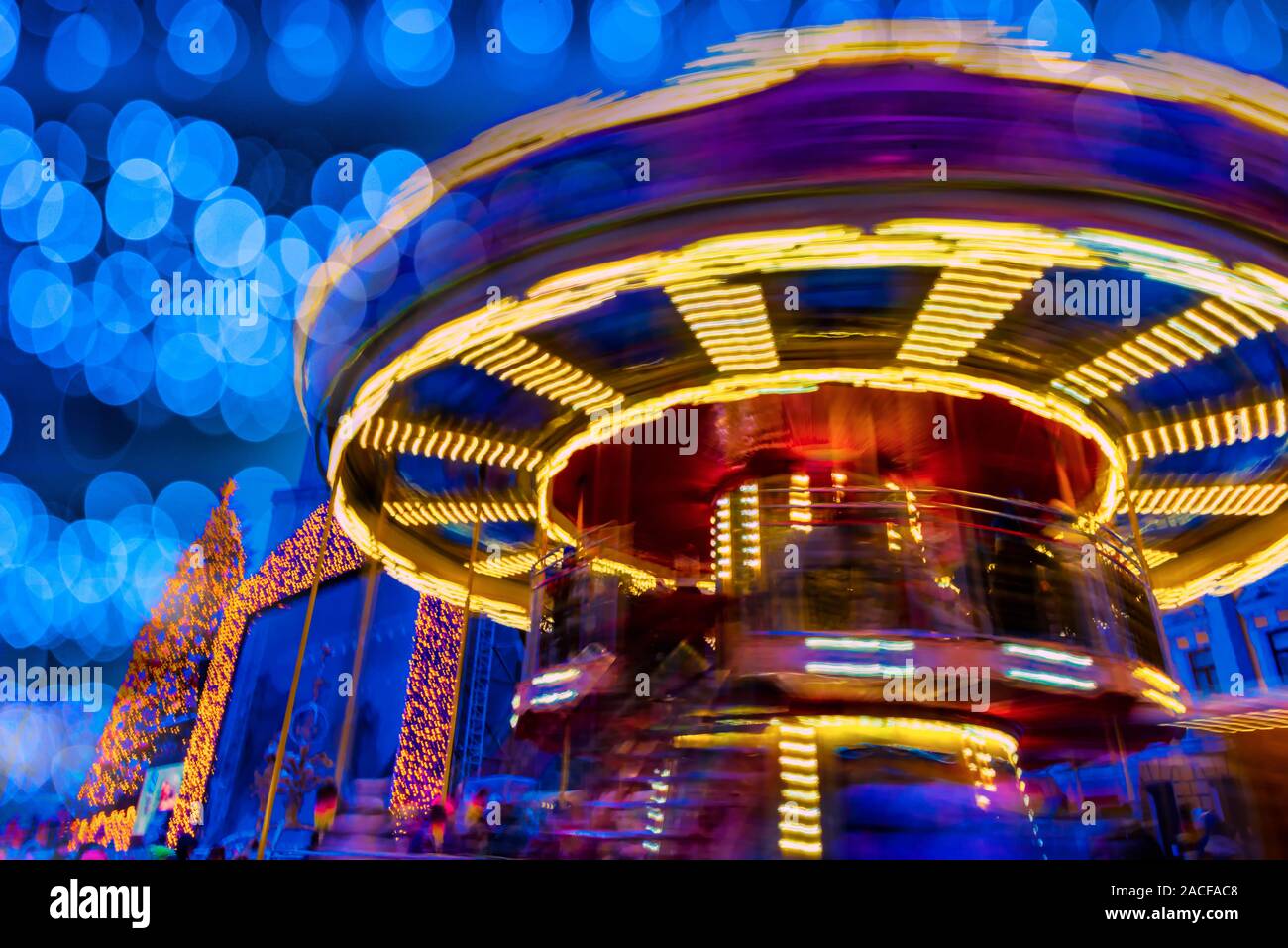 Noël arrière-plan coloré juste. Lumières de l'éclairage de nuit et rotation carrousel avec motion blur Banque D'Images