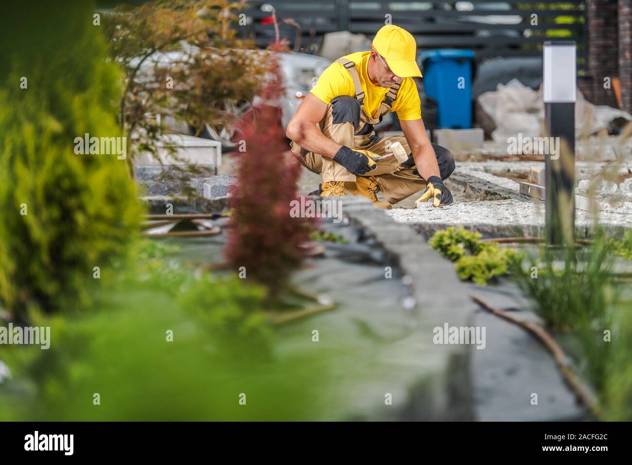 Chemin de jardin. Les hommes de race blanche dans la trentaine de granit Construction Chemin de jardin. Banque D'Images