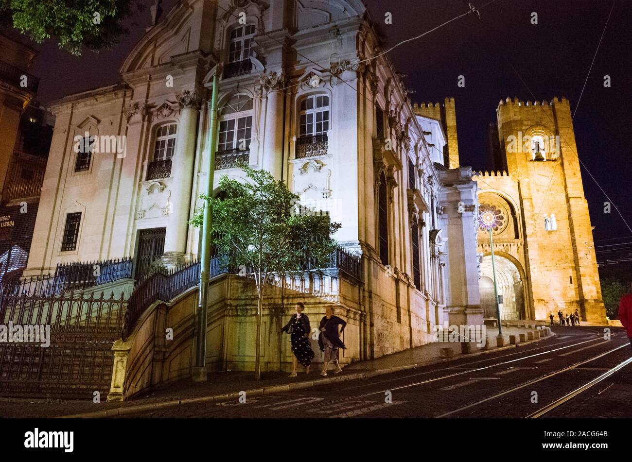 Lisbonne, Portugal : Deux femmes devant la Cathédrale illuminée la nuit et construit en 1147 sur la route principale de Baixa Alfama de districts. Banque D'Images