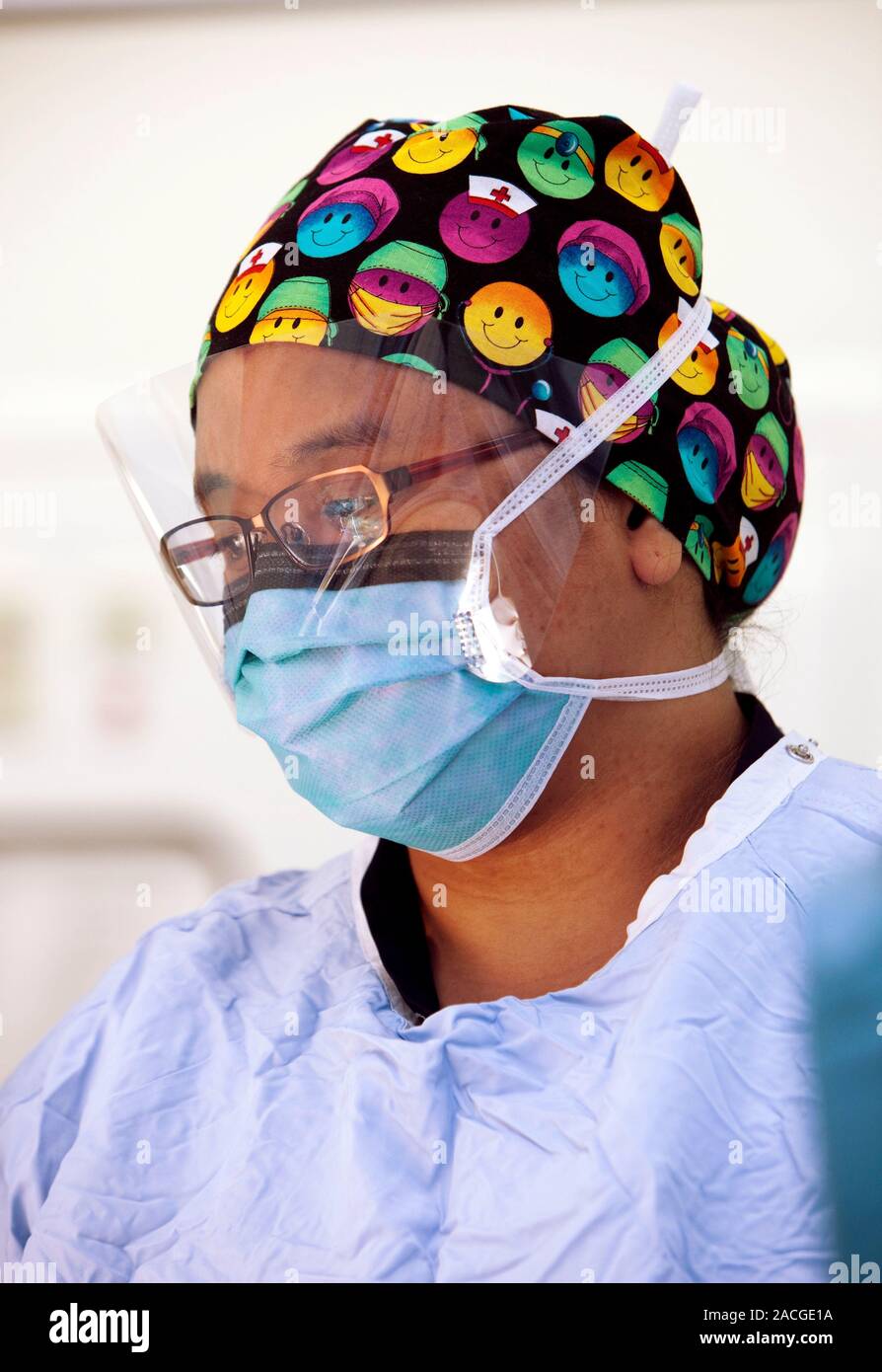 Chirurgien dans le théâtre, portant un foulard et masque en plastique Photo  Stock - Alamy
