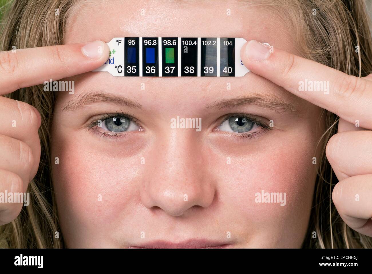Thermomètre de cristaux liquides utilisés par une adolescente pour mesurer  sa température corporelle. Les cristaux liquides dans la bande de changer  de forme et refle Photo Stock - Alamy