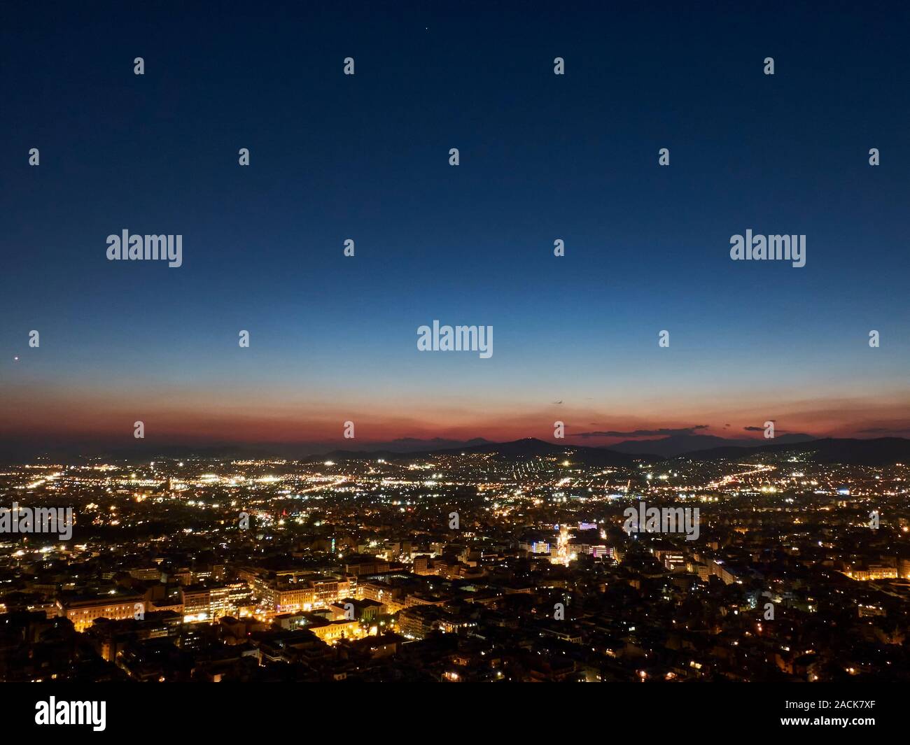 Panorama de la ville au coucher du soleil. Crépuscule paysage avec ville, montagnes et nuages dans le rayons de soleil couchant. Athènes, Grèce. Banque D'Images