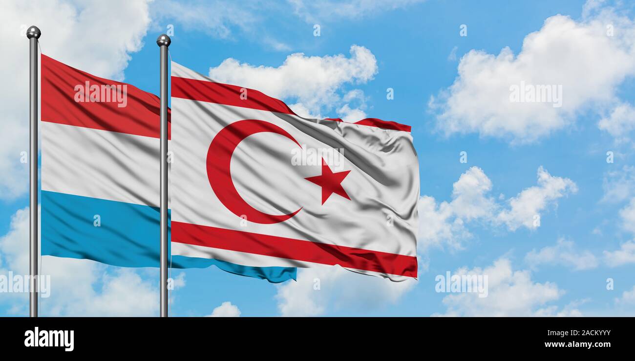 Le Luxembourg et le nord de Chypre drapeaux dans le vent contre ciel bleu nuageux blanc ensemble. Concept de diplomatie, de relations internationales. Banque D'Images