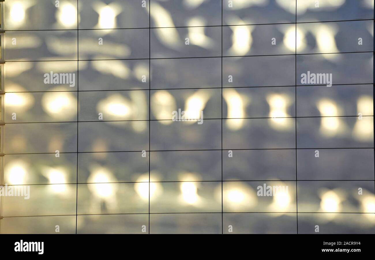 La lumière solaire réfléchie pommelé dans les panneaux sur le mur de l'édifice adjacent Banque D'Images