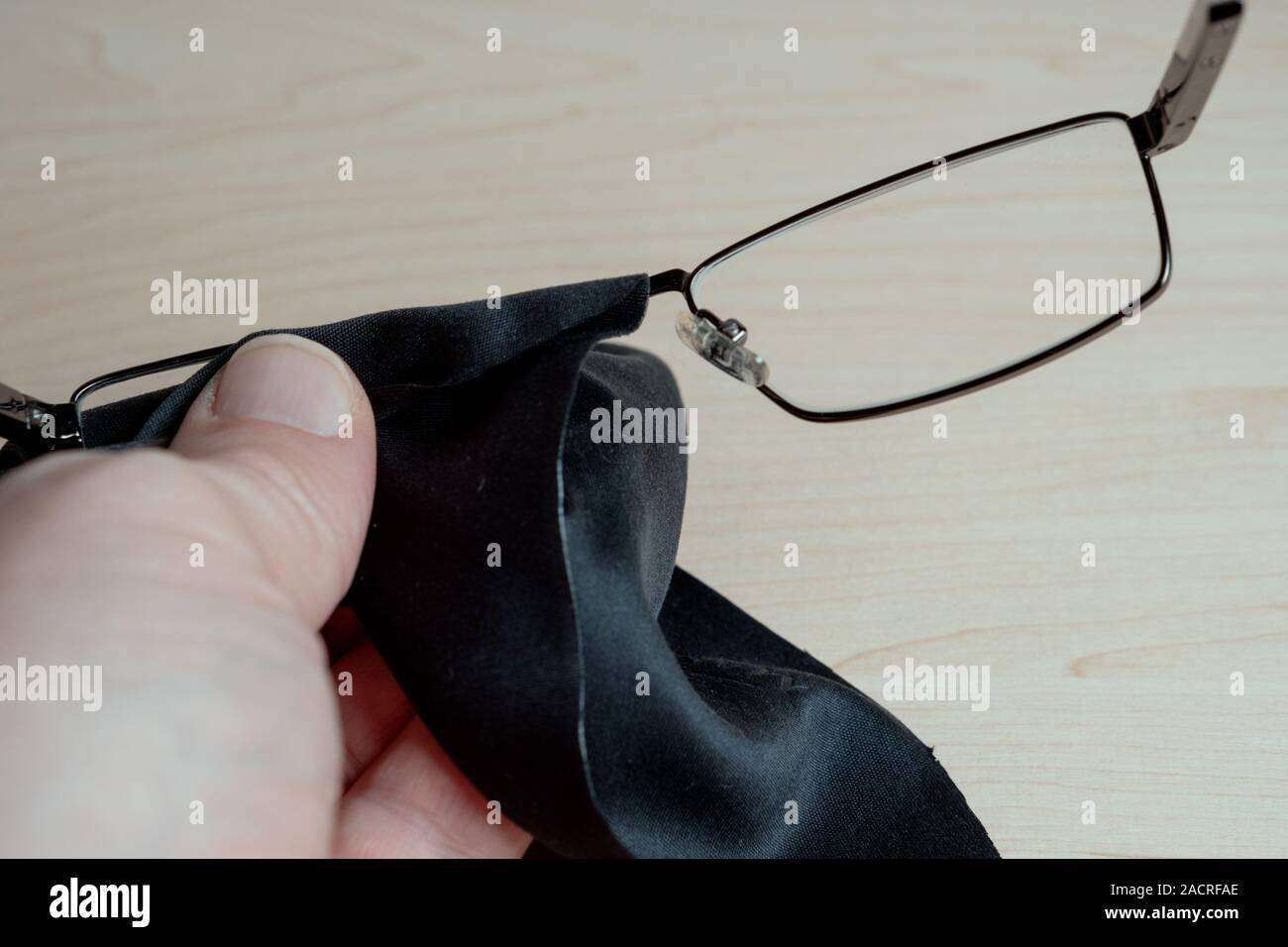 Le nettoyage des verres. Un homme essuie ses lunettes avec un chiffon.  Entreposage et les soins pour les lunettes. Selective focus Photo Stock -  Alamy