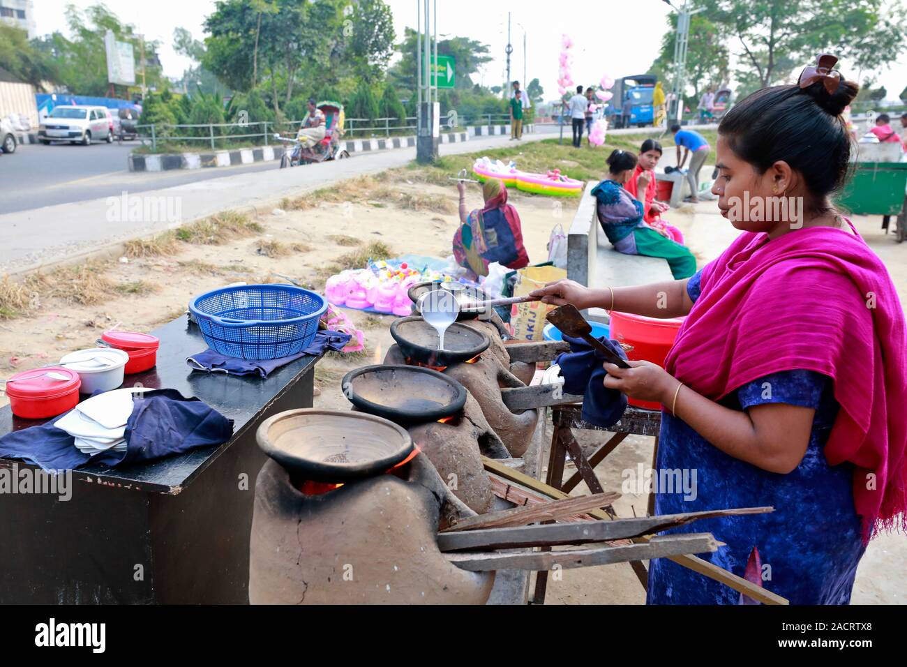 DHAKA, BANGLADESH - Décembre 02, 2019 : Un vendeur de rue, le Bangladesh fait de bouche-arrosage traditionnel Chitay Pithas (gâteau de riz) dans un éventaire routier à Badda dans Banque D'Images