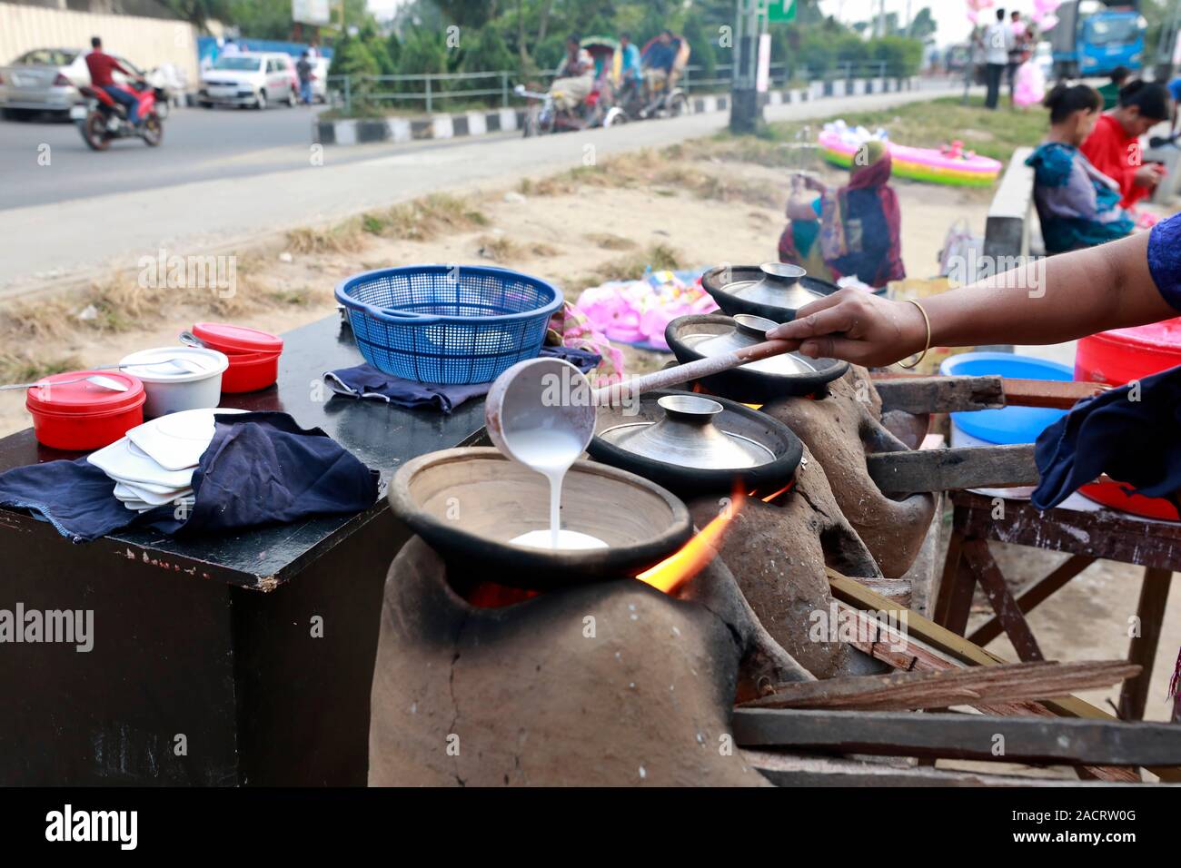 DHAKA, BANGLADESH - Décembre 02, 2019 : Un vendeur de rue, le Bangladesh fait de bouche-arrosage traditionnel Chitay Pithas (gâteau de riz) dans un éventaire routier à Badda dans Banque D'Images