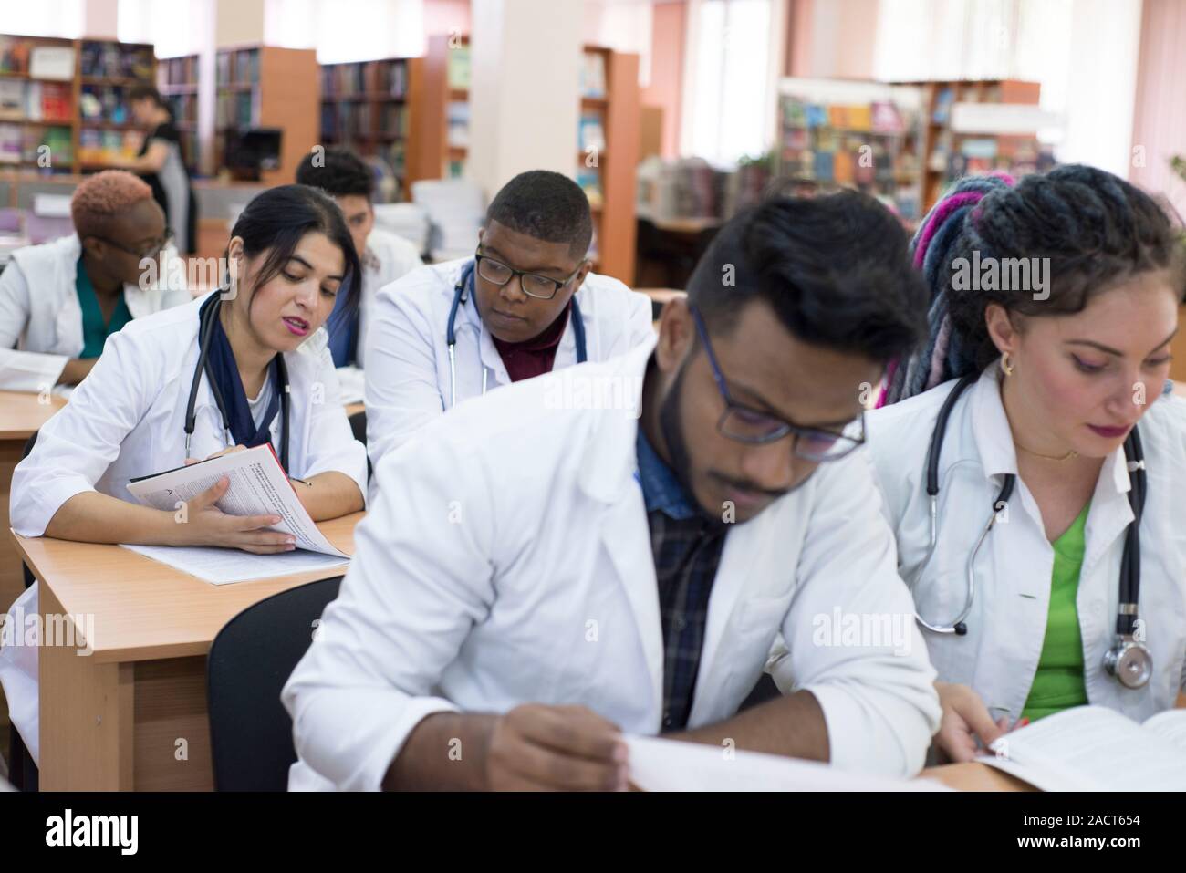 Les étudiants en médecine à puce, race mixte. Assis à la table, examens à l'Université de médecine. Are Smiling Banque D'Images