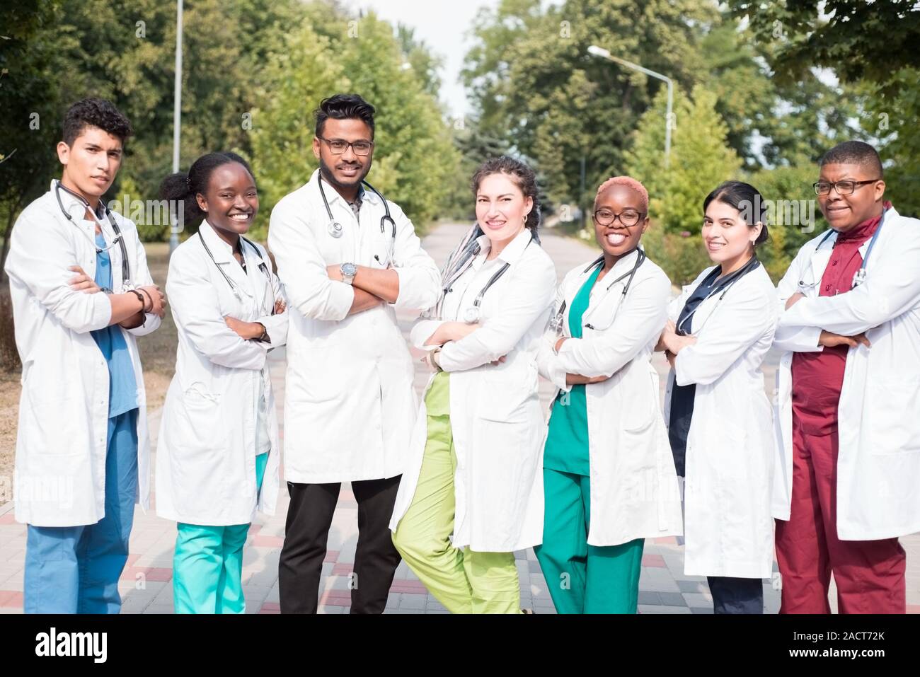 Équipe de jeunes médecins, de race mixte. Posant dans la photo, pour la publicité. Les gens en blouse blanche, avec phonendoscopes, outdoors Banque D'Images