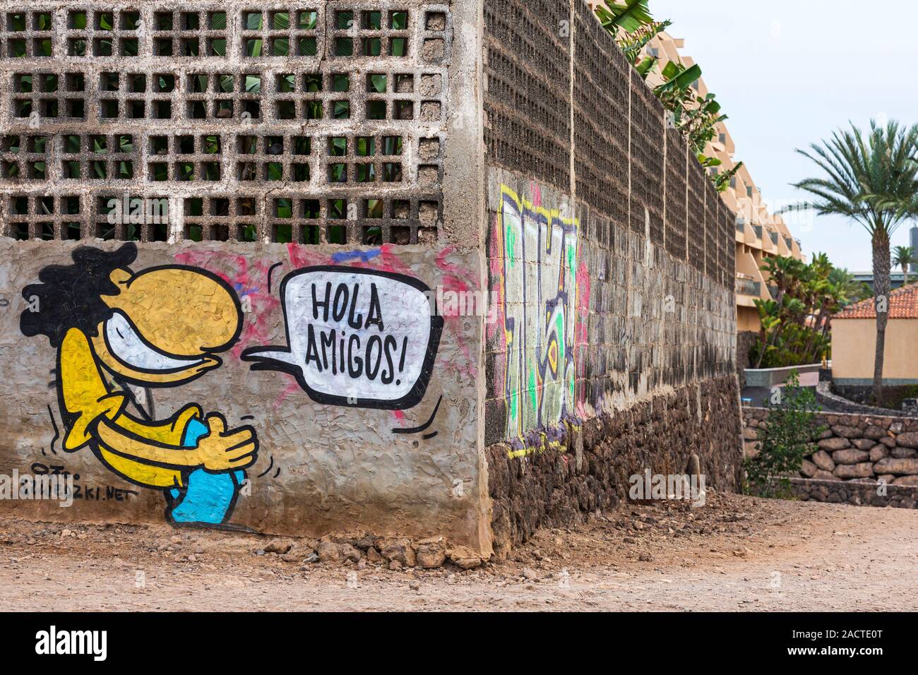 Hola Amigos, graffiti disant bonjour les amis, à l'angle du mur d'un plantation de bananes le long de la côte à pied de Playa Paraiso, Costa Adeje, Tenerife, Ca Banque D'Images