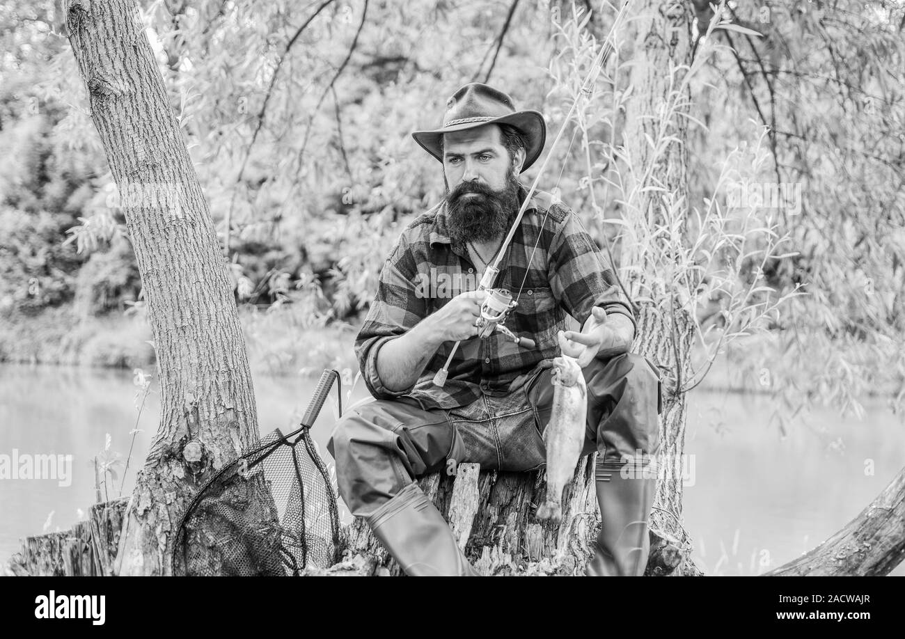 Jour de chance. Pêche à la ligne sport de plein air. Passe-temps de pêche. Trophée de la truite et le pêcheur. Les bonnes choses viennent à ceux qui l'appât. La pêche est toujours mieux de l'autre côté du lac. L'homme poisson satisfait. Banque D'Images