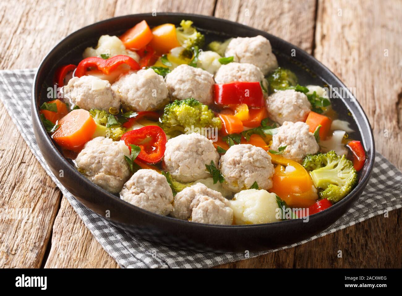 Servir la soupe avec des boulettes de viande et légumes close-up dans une assiette sur la table horizontale. Banque D'Images