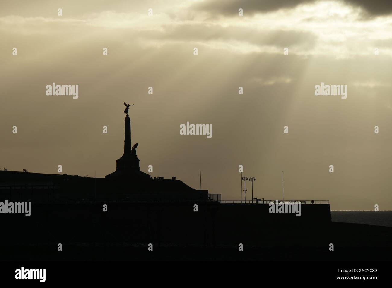 Vue sur le coucher du soleil d'Aberystwyth prise en novembre depuis la promenade montrant les bâtiments en silhouette Banque D'Images