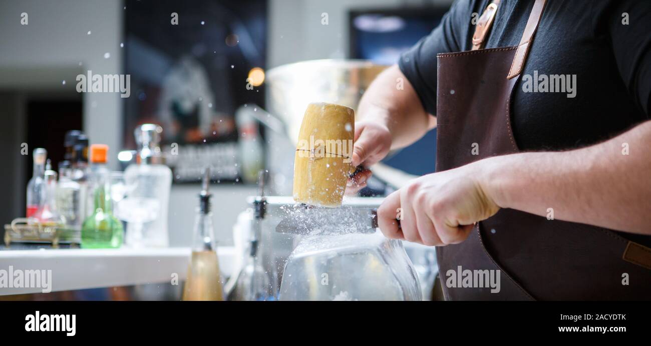 La glace se brise barman avec marteau en bois Banque D'Images