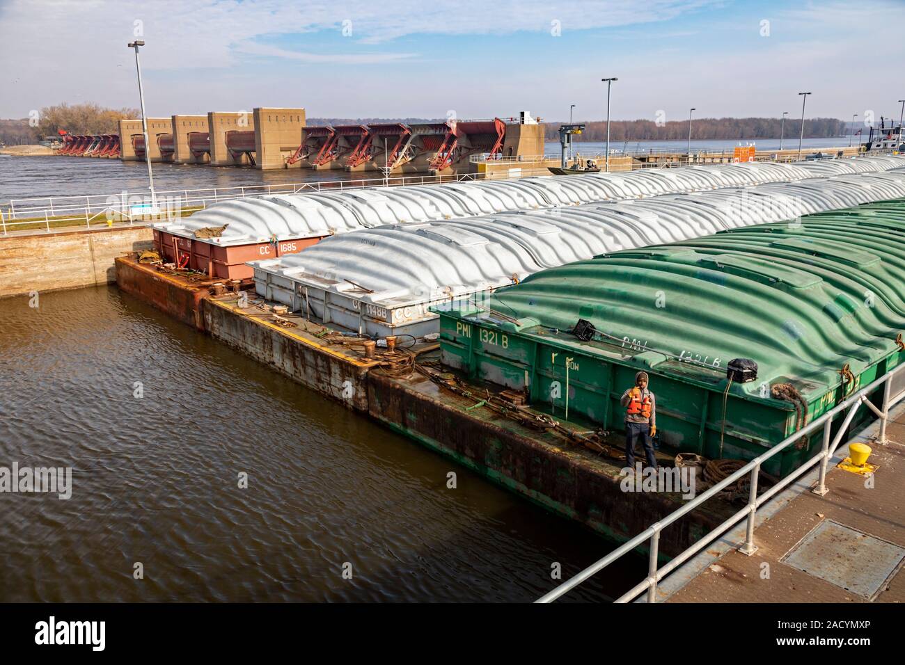 New York City, New York - Un remorqueur pousse barges contenant du maïs et du soja dans l'écluse et Dam No 16 sur la partie supérieure du fleuve Mississippi. Un travailleur sur t Banque D'Images