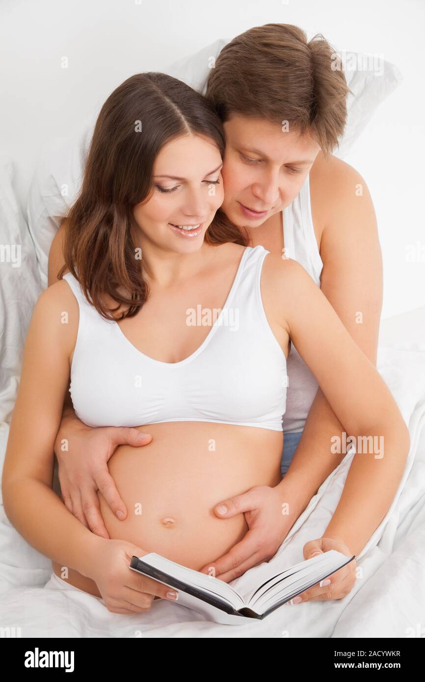 Femme enceinte et son mari reading book Banque D'Images