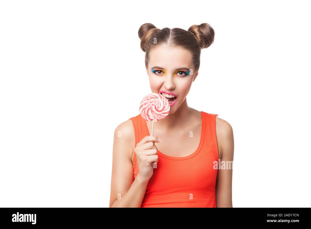 Fille brune avec des brioches biting lollipop Banque D'Images