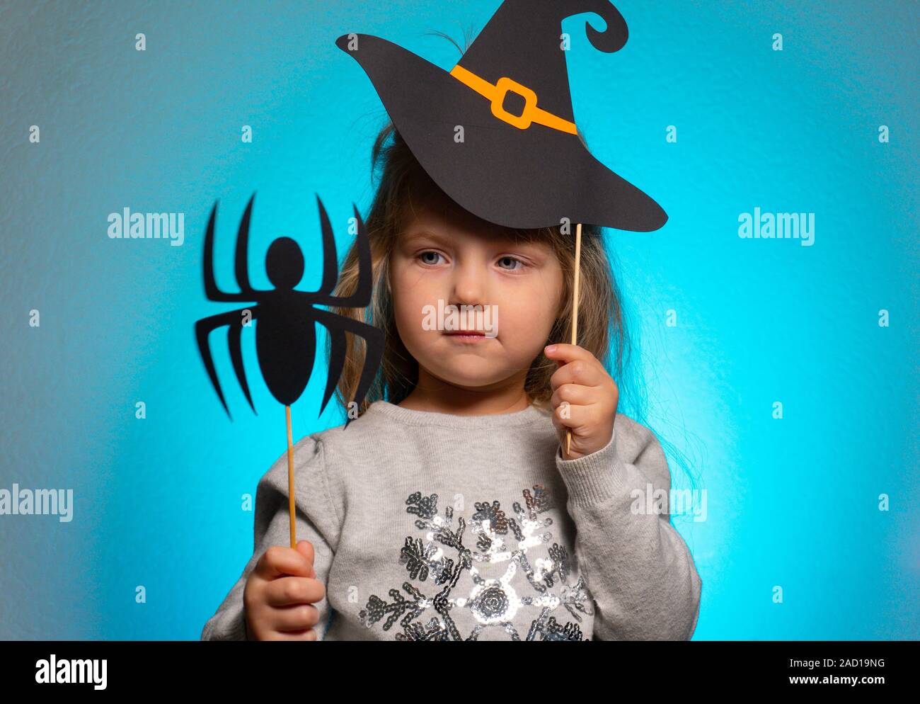Petite fille sorcière pour halloween à la recherche à l'araignée de papier Banque D'Images
