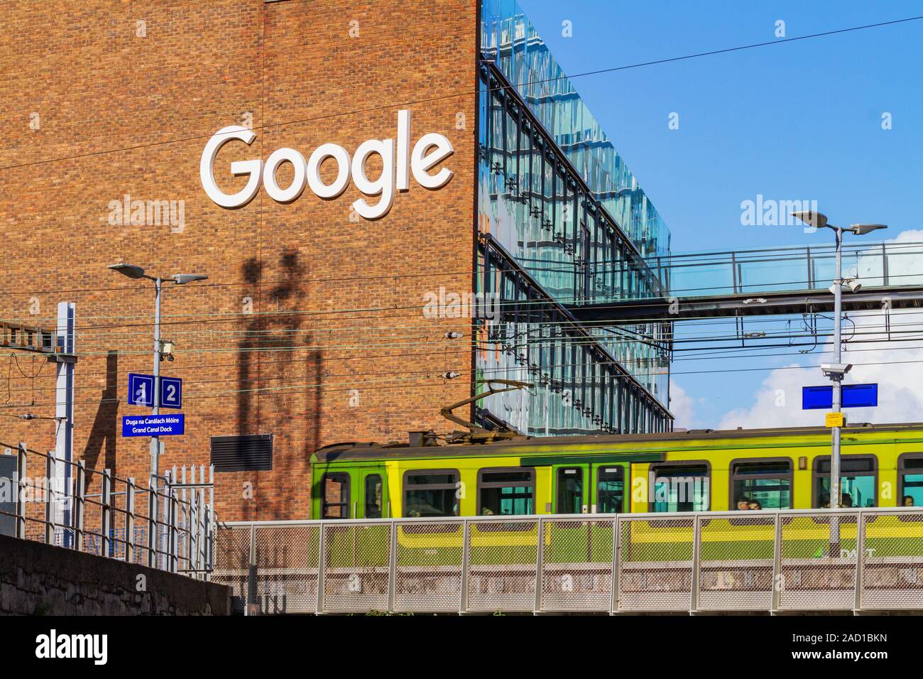 Les bureaux de la société Google, siège européen d'immeuble de bureaux avec DART vert train électrique. Dublin, Irlande, le système de transport public ferroviaire électrique Banque D'Images