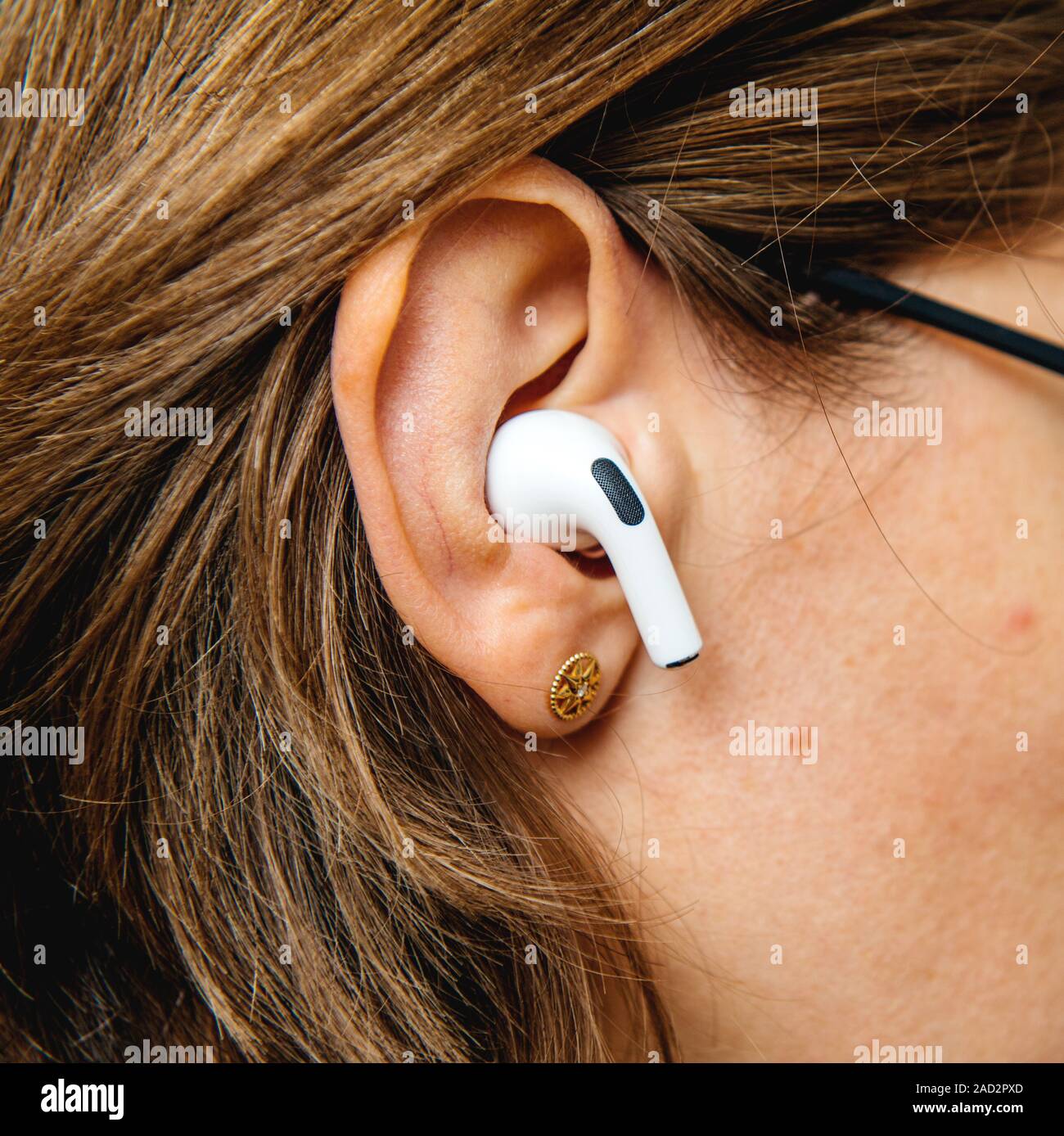 Paris, France - Oct 30, 2019 : side view of woman in-ear nouveaux ordinateurs Apple AirPods Pro casque avec suppression du bruit active pour un son enveloppant Banque D'Images