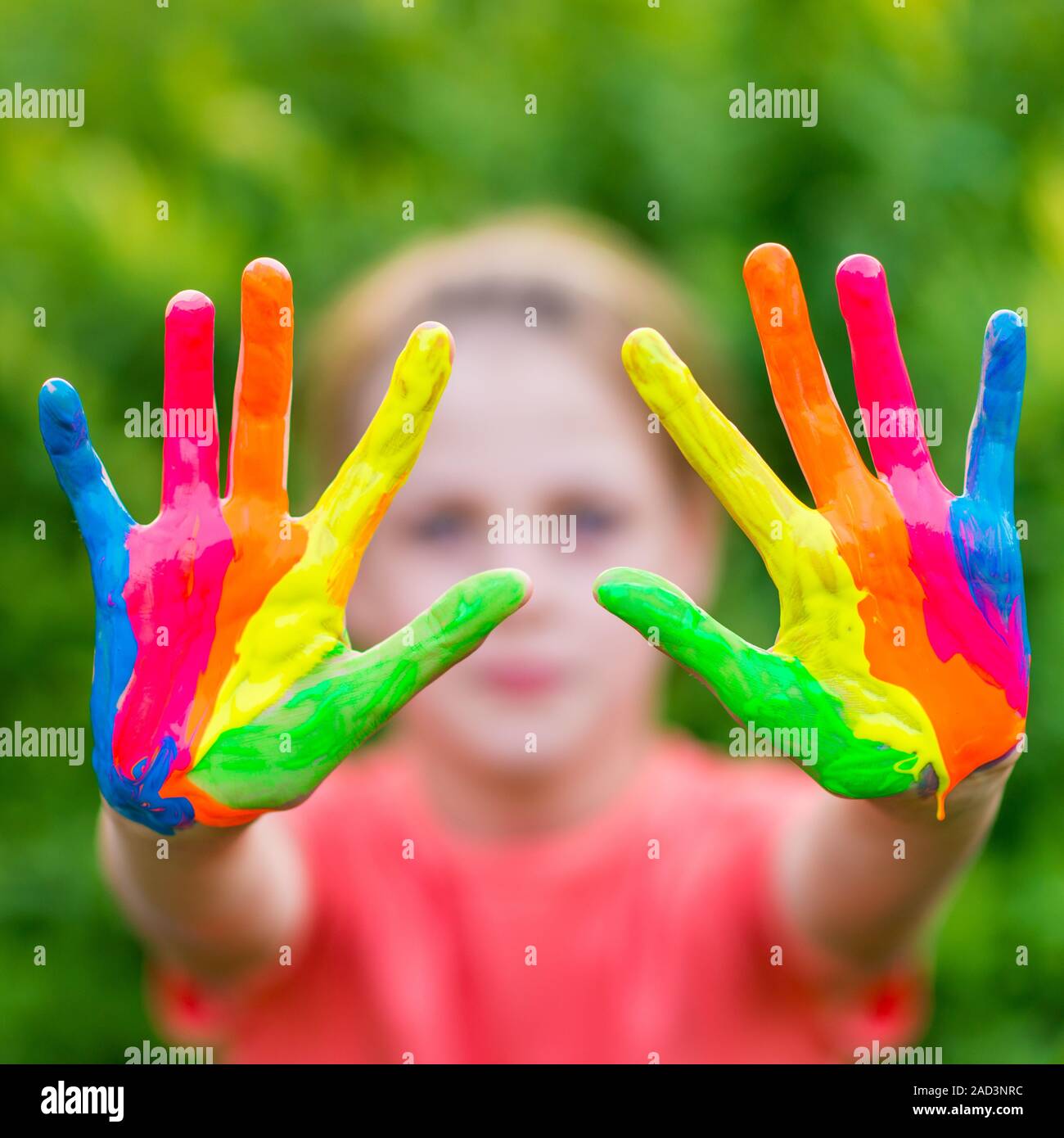 Petite fille aux mains peintes dans les peintures colorées prêt pour main imprime Banque D'Images