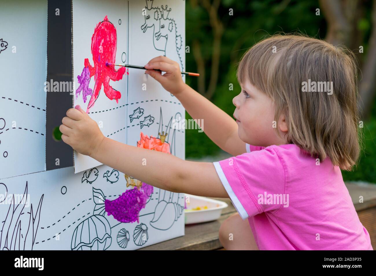 Jeune fille peinture maison en carton Banque D'Images