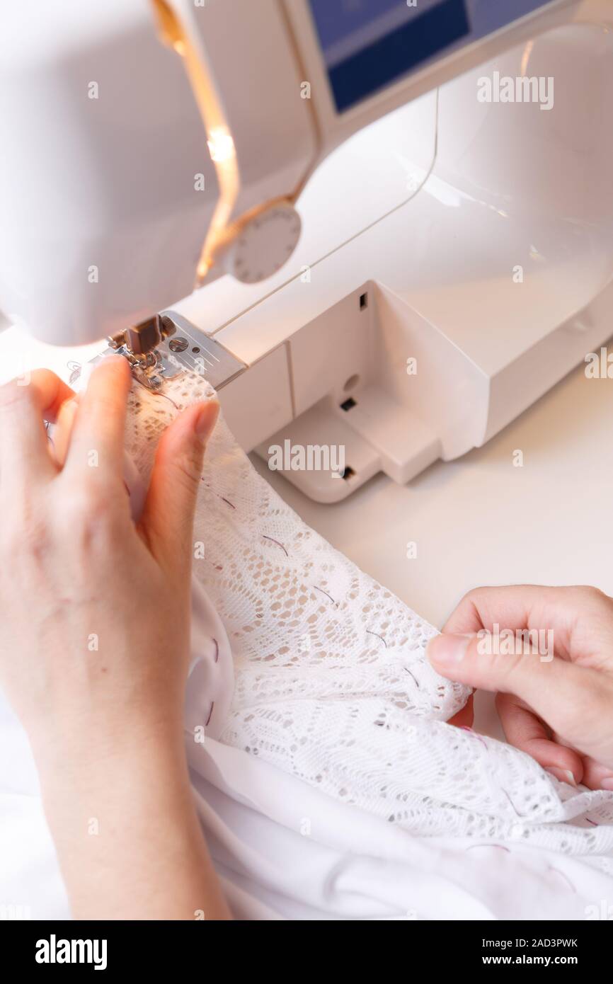 Girl gribouillis sur tissu machine à coudre Banque D'Images