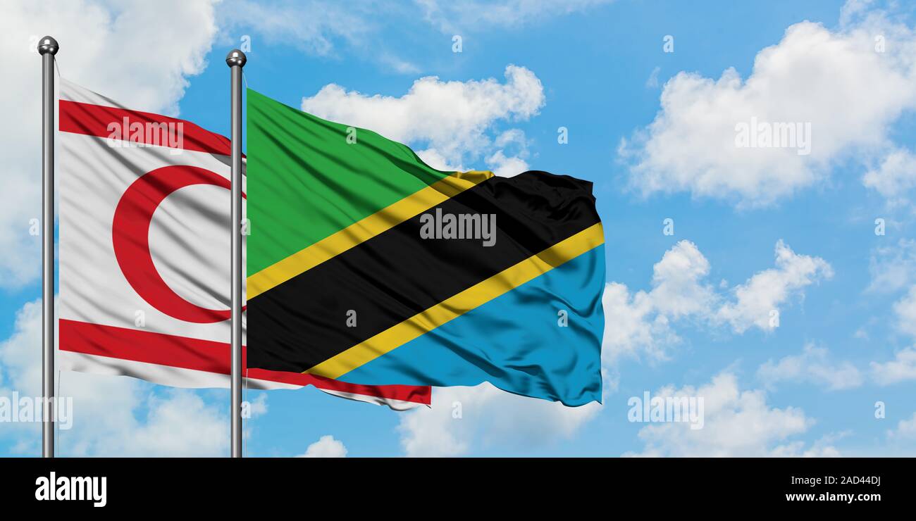 Le nord de Chypre et de brandir le drapeau de la Tanzanie dans le vent contre ciel bleu nuageux blanc ensemble. Concept de diplomatie, de relations internationales. Banque D'Images