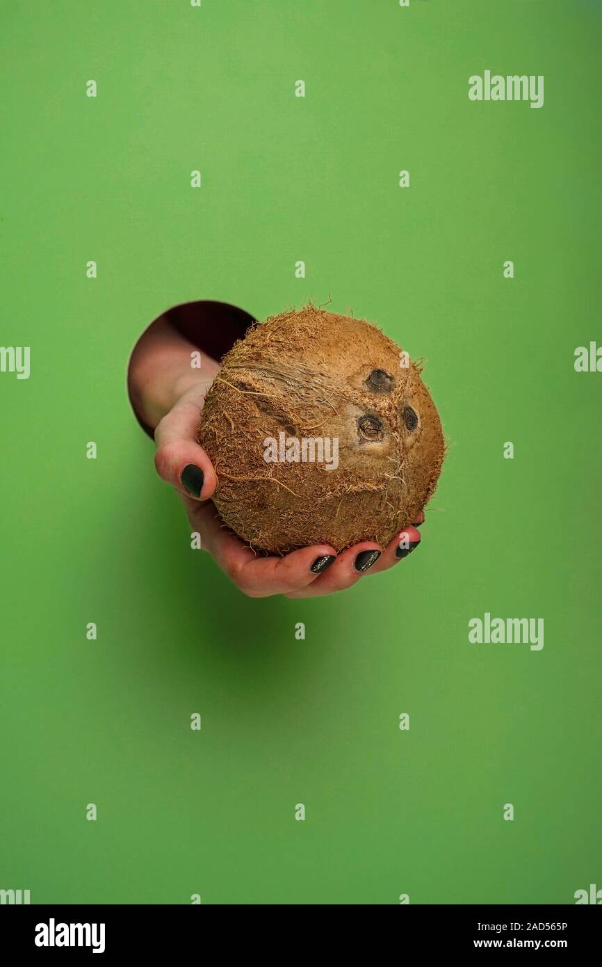 Femme main dans un trou circulaire dans l'arrière-plan Banque D'Images