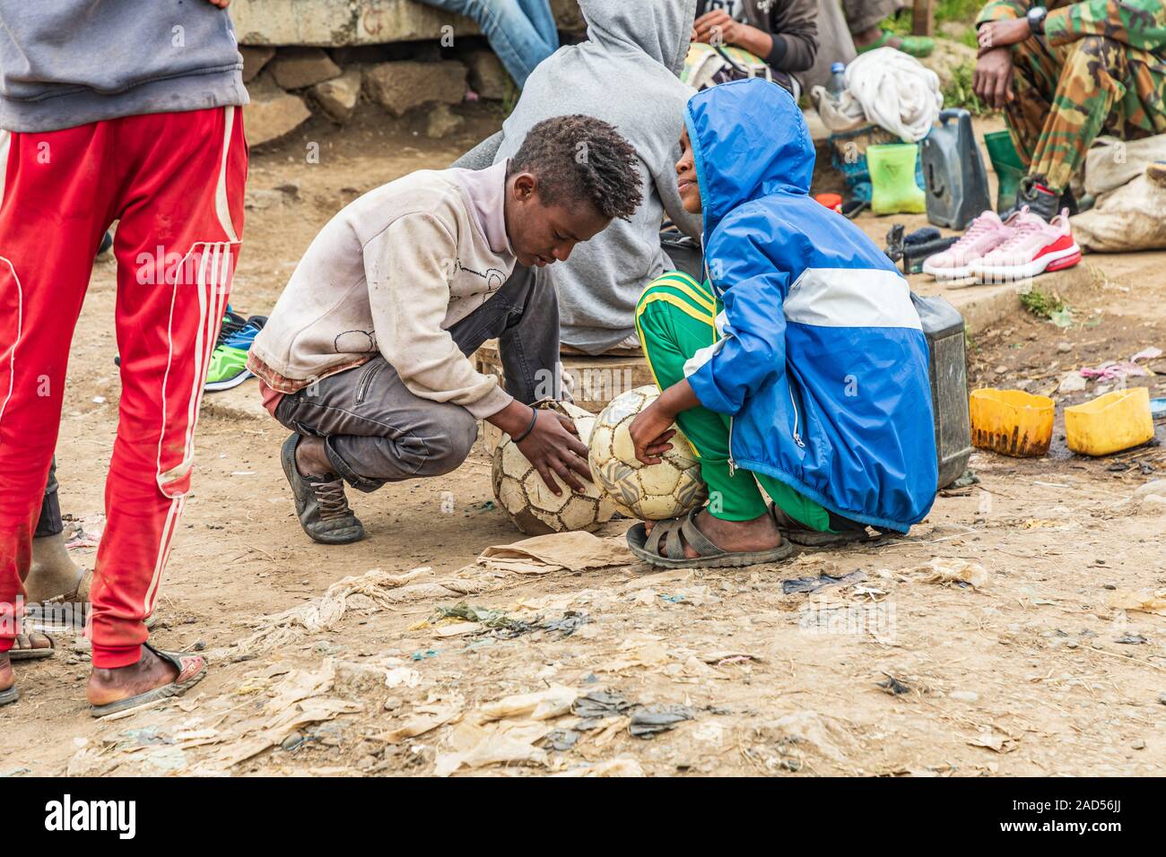 L'Éthiopie. L'Amhara. Déchargent. 21 septembre, 2019. Deux garçons la réparation de ballons de foot dans le marché d'écorcer. Banque D'Images