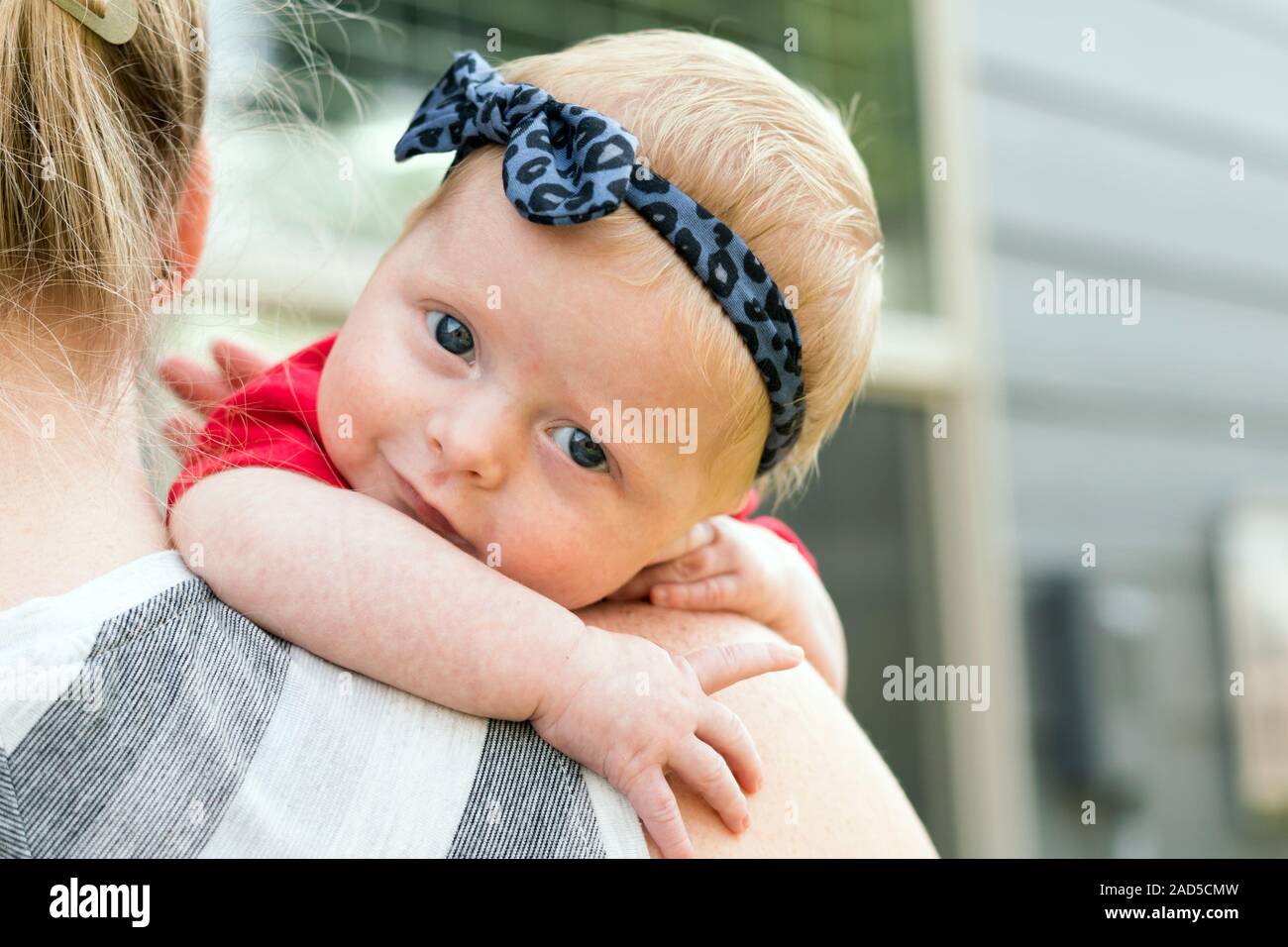 Mother Holding Happy Baby avec des yeux bleus Banque D'Images