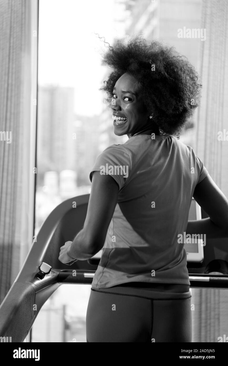 L'afro-américain femme courir sur un tapis roulant Banque D'Images