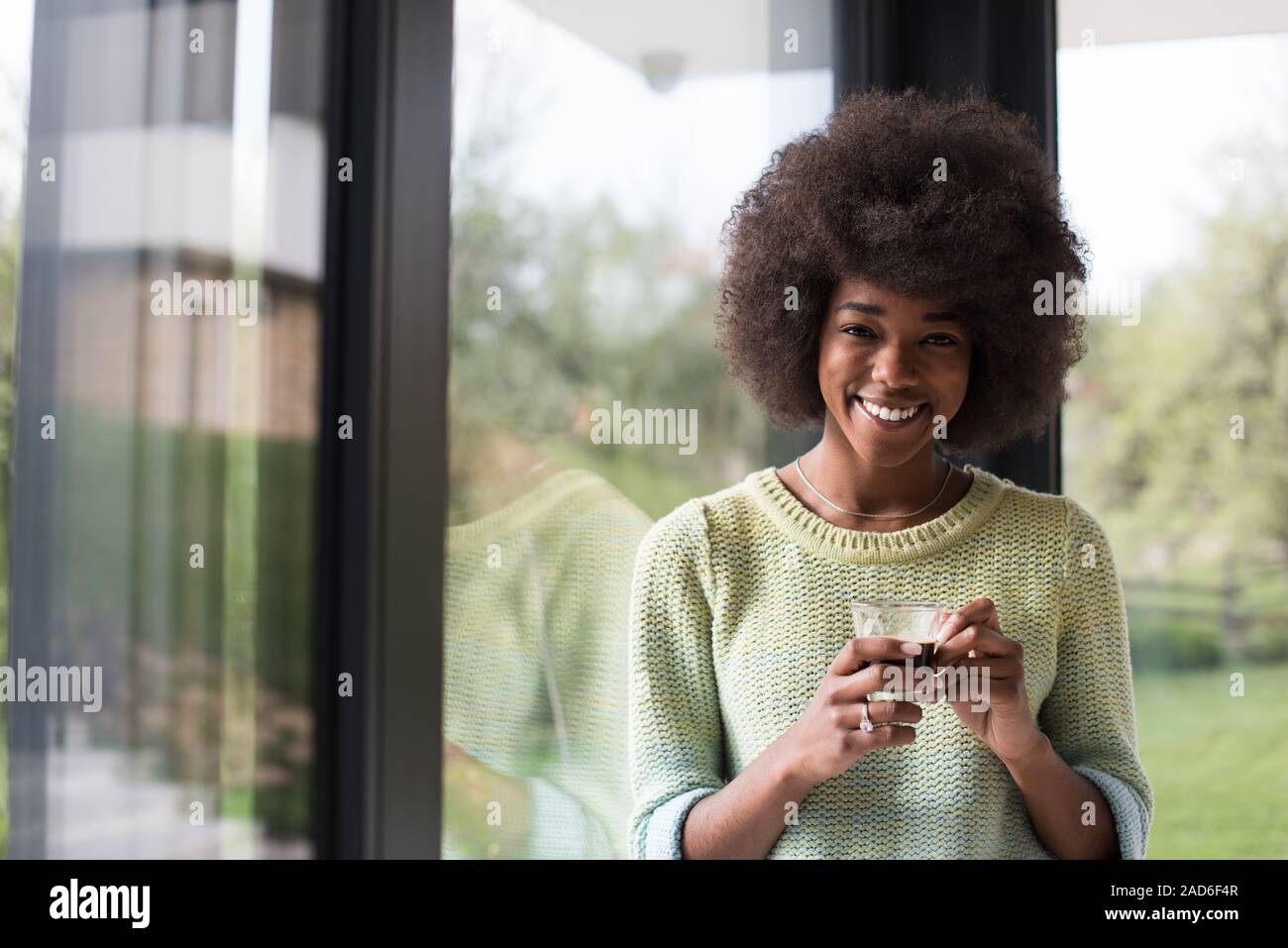 African American Woman boire du café en regardant par la fenêtre Banque D'Images