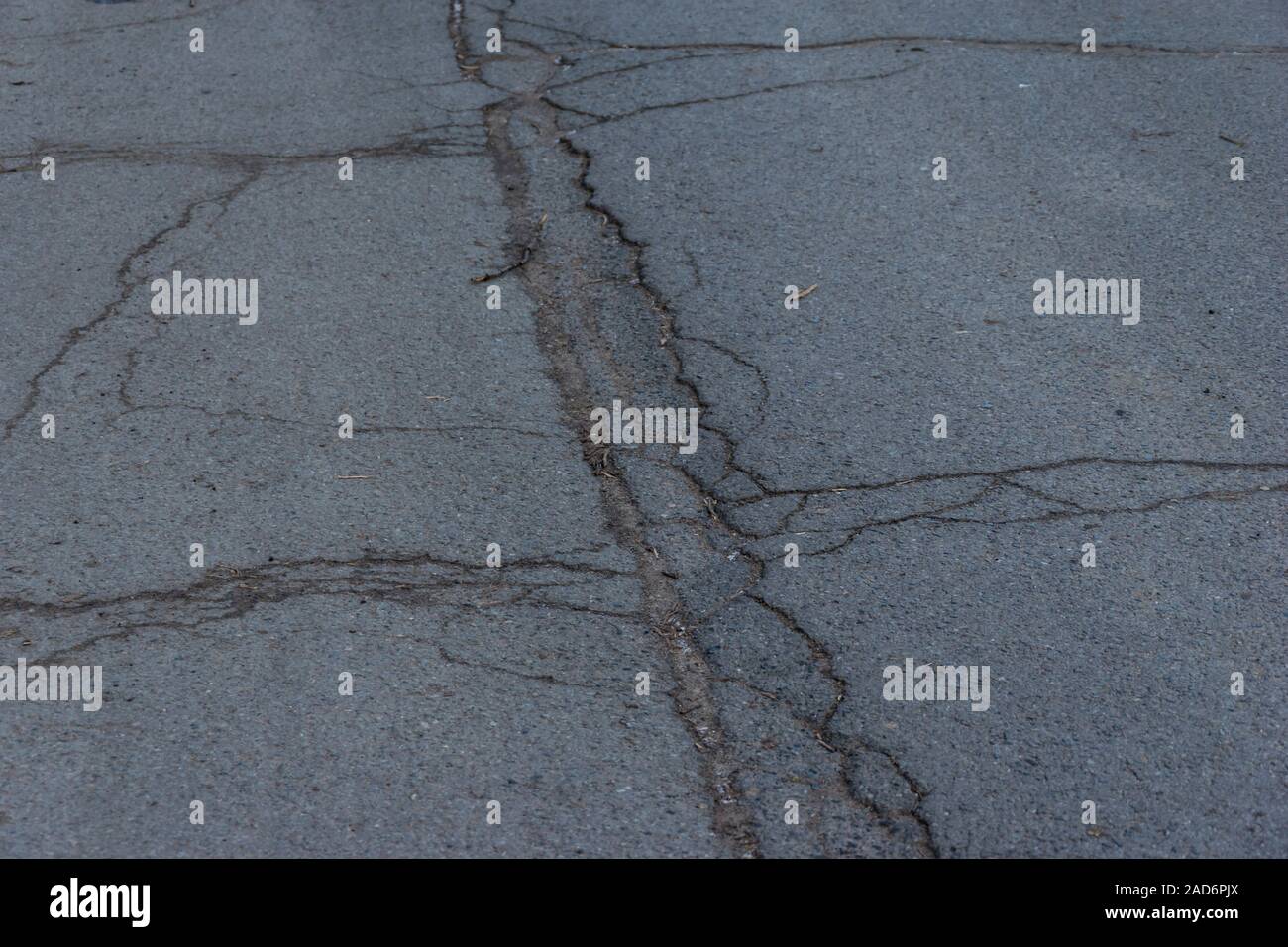 Route asphaltée surface avec de petites fissures et de dommages-intérêts. Trottoir route asphaltée avec des fissures. Étage. La texture de la route goudronnée par des fissures. Abstract background Banque D'Images