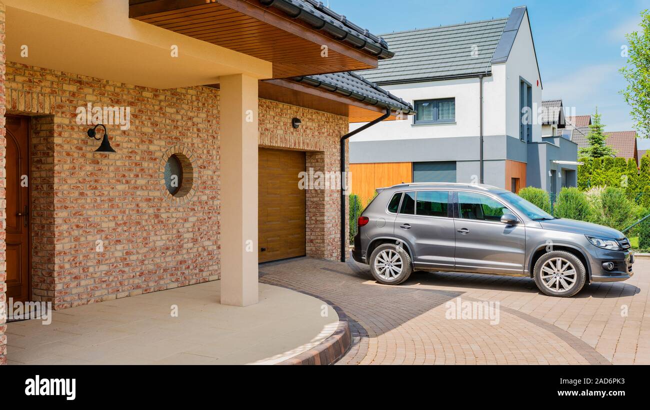 Maison d'habitation avec silver suv voiture garée sur la voie d'en face Banque D'Images