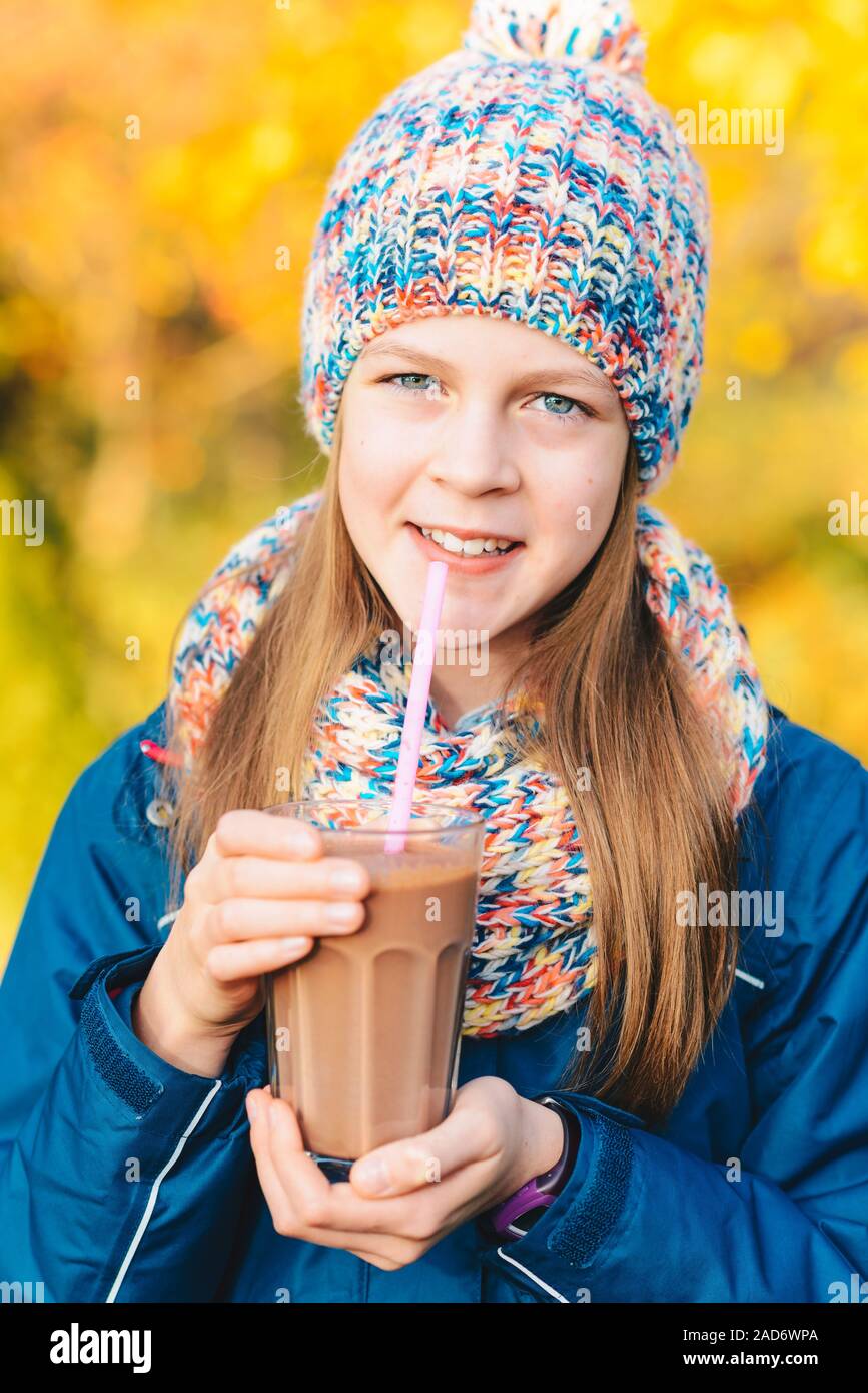 Happy smiling young girl de boire du lait au chocolat Banque D'Images