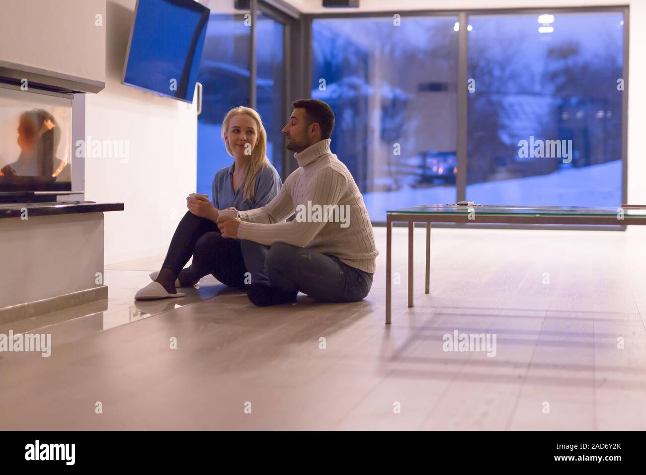 Couple heureux en face de cheminée Banque D'Images
